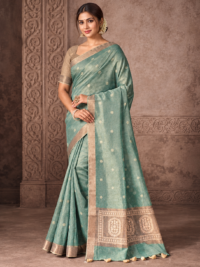 Model wearing a sea-green saree with small floral motifs, a gold-tone border and a floral medallion pallu.