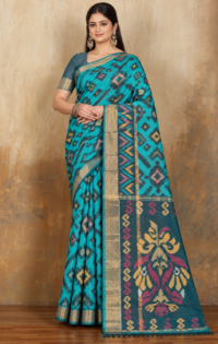 Model wearing a teal cotton semi Patola saree with a dark patterned pallu draped from the shoulder.